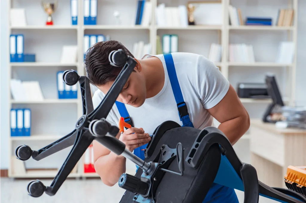 Técnico ajustando los tornillos y la base de una silla de oficina.